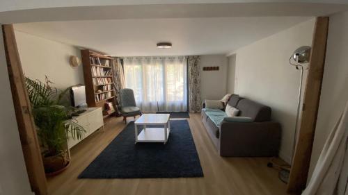 un salon avec un canapé et une table dans l'établissement 30mn de Paris st lazare en train, studio 42 m2, à Verneuil-sur-Seine