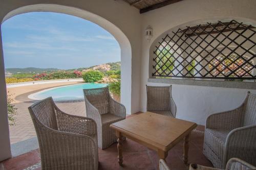 a patio with a table and chairs and a pool at Beautiful Il Giardino degli Oleandri one bedroom Premium sleeps 4 in Liscia di Vacca