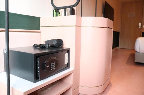 a microwave oven on a shelf in a room at The Quarter Ratchathewi by UHG in Bangkok