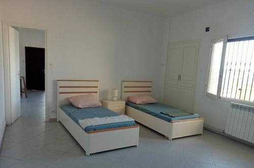El MouradiaにあるVilla Dar Annetteのベッド2台が隣同士に設置された部屋です。