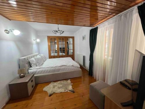 um quarto com uma cama grande e piso em madeira em Vila Tequila Sinaia em Sinaia