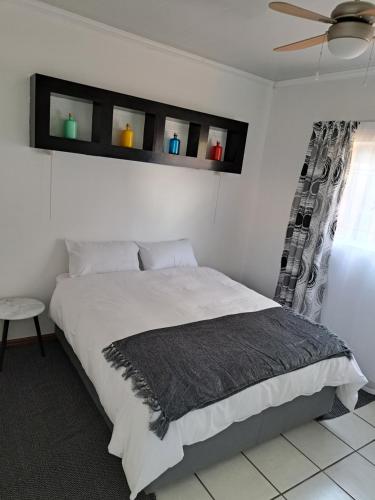 a bedroom with a bed and a ceiling fan at Partridge Place in Kempton Park