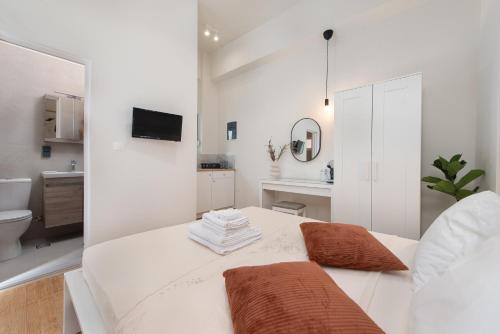 a white room with a bed and a bathroom at Fani's City Apartment in Rhodes Town