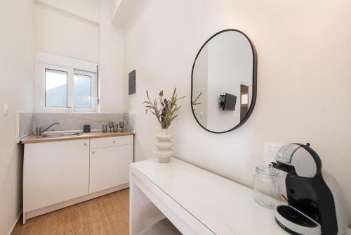 a white bathroom with a mirror and a sink at Fani's City Apartment in Rhodes Town