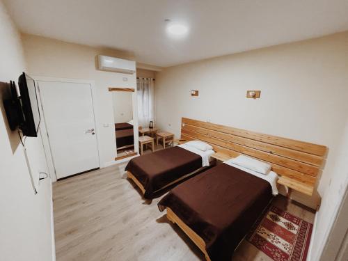 a hotel room with two beds and a television at At Pikotiko's - Korca City Rooms for Rent in Korçë