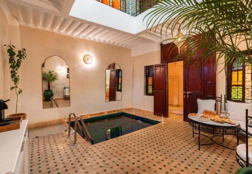 a swimming pool in a room with a house at Riad Privé Dar L'Étoile - Piscine & Petit Déj inclus in Marrakesh