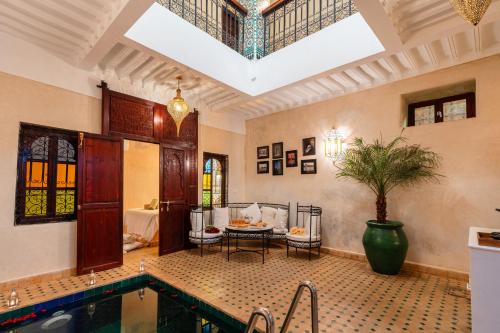a living room with a swimming pool and a table at Riad Privé Dar L'Étoile - Jacuzzi Piscine & Petit Déj inclus in Marrakech