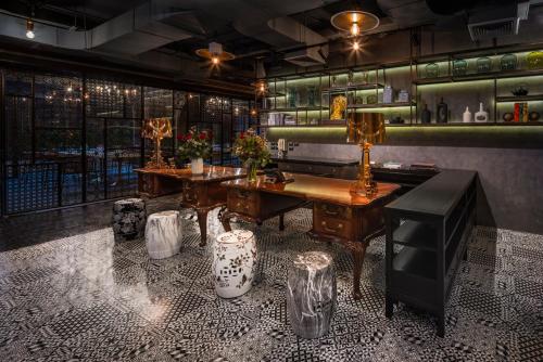 a bar with a table and a bench in a room at PASSA Hotel Bangkok in Bangkok