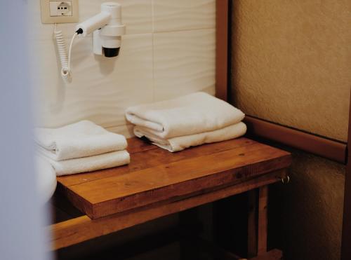 two towels sitting on a wooden table in a bathroom at At Pikotiko's - Korca City Rooms for Rent in Korçë