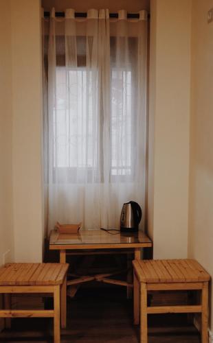 a table and two benches in front of a window at At Pikotiko's - Korca City Rooms for Rent in Korçë
