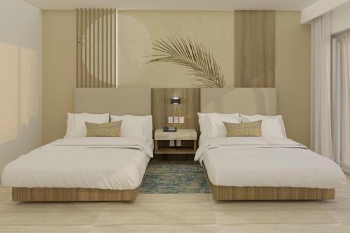 two beds in a hotel room with at Marriott Cancun, An All-Inclusive Resort in Cancún