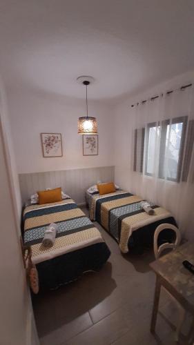 three beds in a room with a chandelier at AbumaHouse in Los Llanos de Aridane