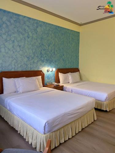two beds in a hotel room with two beds sidx sidx sidx at Hotel Sandakan in Sandakan