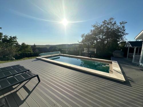 a swimming pool on top of a wooden deck at Tiétek a HÁZ in Mogyoród