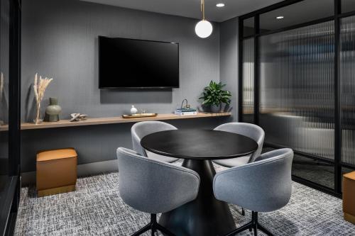 a dining room with a table and chairs and a tv at Le Centre Sheraton Montreal Hotel in Montréal