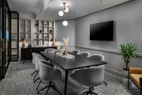 a dining room with a table and chairs and a tv at Le Centre Sheraton Montreal Hotel in Montréal