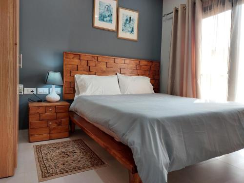 een slaapkamer met een groot bed en een raam bij Aqua View Apartments in Bijilo