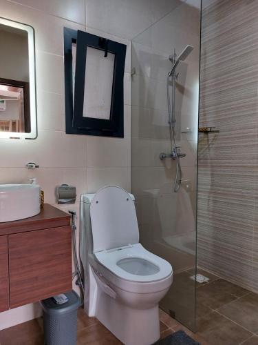 een badkamer met een toilet en een glazen douche bij Aqua View Apartments in Bijilo