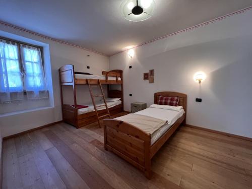 a bedroom with two bunk beds and a window at Trilocale Giustino Vadaione in Giustino