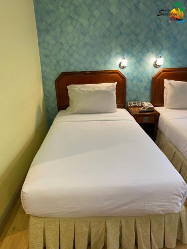 a bedroom with two beds in a room at Hotel Sandakan in Sandakan