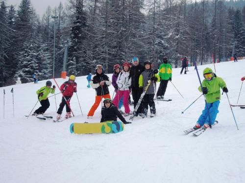 a group of people standing in the snow with a snowboard at Gasthof Berghof in Semmering