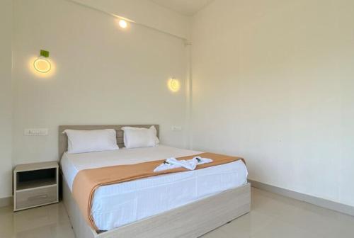 a bedroom with a bed and a tv in it at Dazzle Mount Resort in Kalpetta