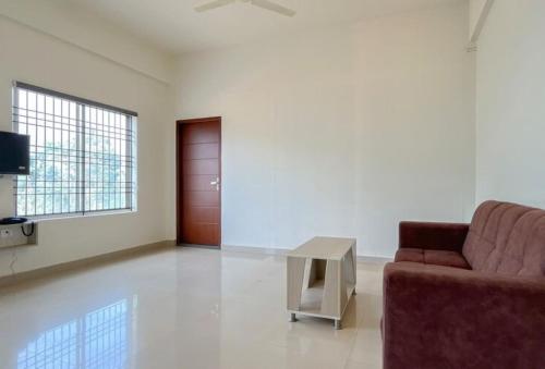 a living room with a couch and a table at Dazzle Mount Resort in Kalpetta