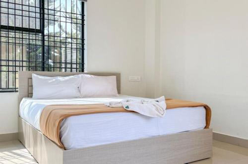 a bed with a wooden frame in a bedroom at Dazzle Mount Resort in Kalpetta