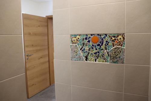 a bathroom with a mosaic tile on the wall at Ferienwohnung Zwirn ... auf dem Uhlenköper-Camp Uelzen in Uelzen