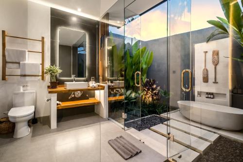 La salle de bains est pourvue d'une baignoire, d'un lavabo et de toilettes. dans l'établissement Sarang Cocoon Villa Ubud by BaliSuperHost, à Ubud