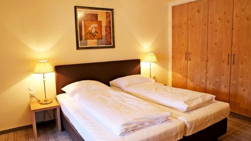 a bedroom with a bed with two pillows at Gasthof Pension Madseiterhof in Tux