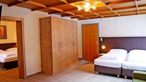 a bedroom with two beds and wooden cabinets at Gasthof Pension Madseiterhof in Tux