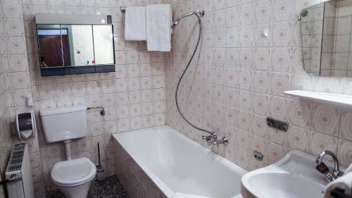 a bathroom with a sink and a toilet and a bath tub at Gasthof Pension Madseiterhof in Tux