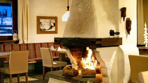 a fireplace in a room with chairs and a table at Gasthof Pension Madseiterhof in Tux