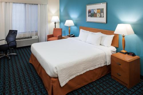 a hotel room with a large bed and a chair at Fairfield by Marriott Ruston in Ruston
