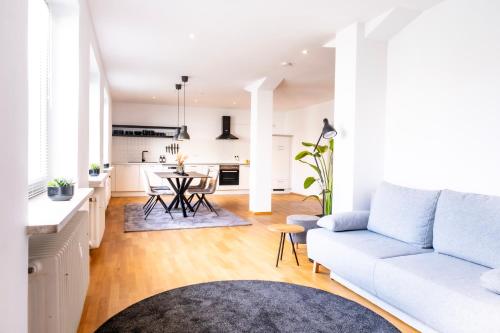 ein Wohnzimmer mit einem weißen Sofa und einer Küche in der Unterkunft stycoz: Modernes Loft in der historischen Altstadt Memmingen in Memmingen