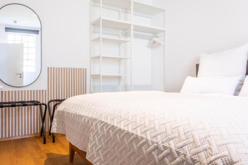 1 dormitorio con cama blanca y espejo en stycoz: Modernes Loft in der historischen Altstadt Memmingen en Memmingen