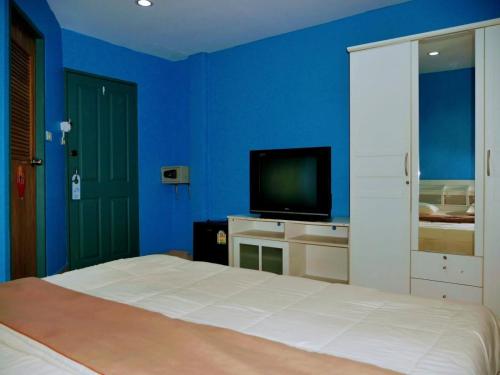a blue bedroom with a bed and a television at Marine paradise Encore in Pattaya South