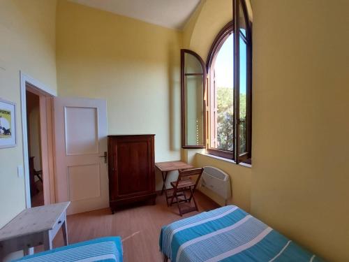 a bedroom with a bed and a table and a window at Appartamento Mare Blu in Cavo