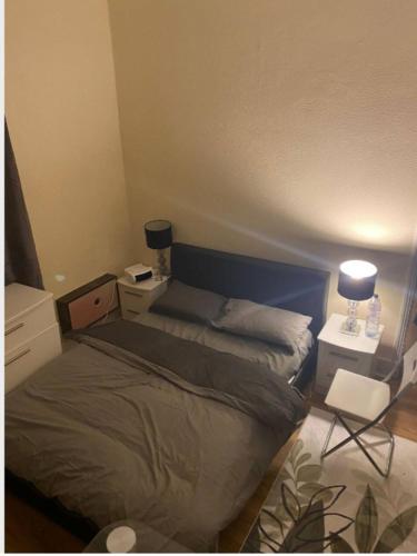 a small bedroom with a bed and a chair at Double room #1 in Hounslow