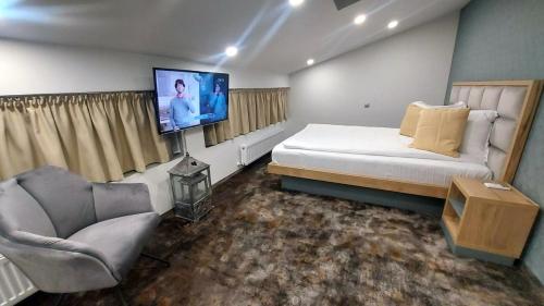 a bedroom with a bed and a flat screen tv at Hotel Stefani in Sibiu