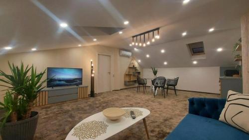 ein Wohnzimmer mit einem blauen Sofa und einem TV in der Unterkunft Hotel Stefani in Sibiu