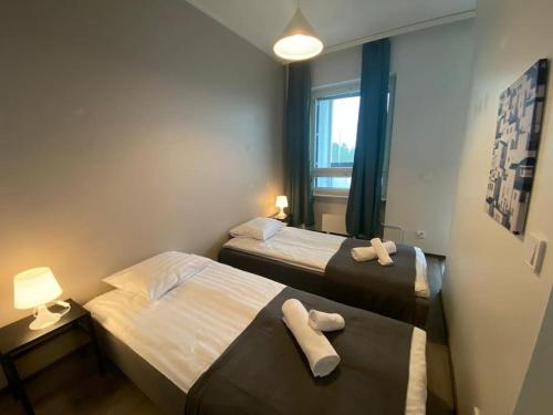 - 2 lits dans une chambre d'hôtel avec des serviettes dans l'établissement Kotimaailma - Tyylikäs 3MH asunto Espoossa, à Espoo