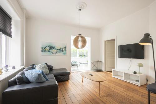 a living room with a couch and a tv at Central Lyngby Apartments in Kongens Lyngby