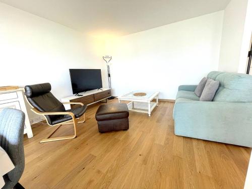 un soggiorno con divano blu e sedia di Appartement Port Le Pouliguen a Le Pouliguen