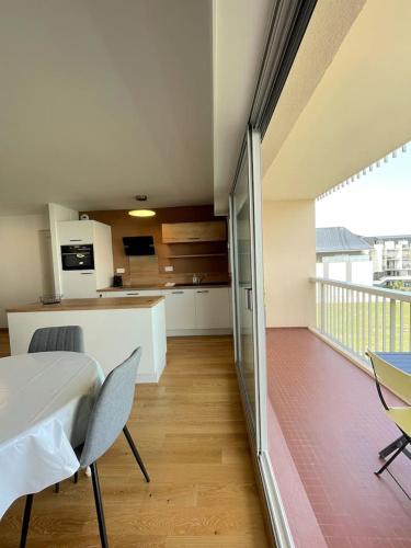 une cuisine et un salon avec une table et des chaises dans l'établissement Appartement Port Le Pouliguen, au Pouliguen