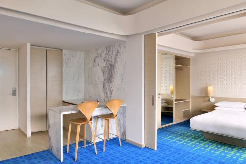 a hotel room with a bed and two chairs at Fairfield by Marriott Hyderabad Gachibowli in Hyderabad