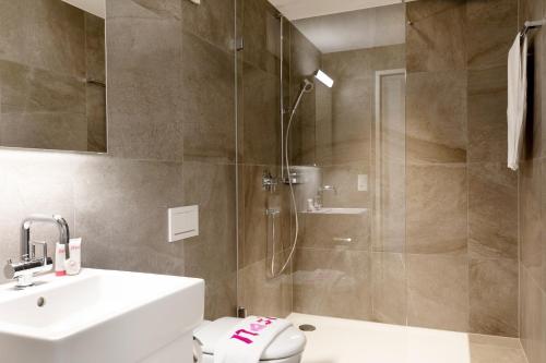 een badkamer met een douche, een toilet en een wastafel bij Nest - Elsastrasse 16 in Zürich