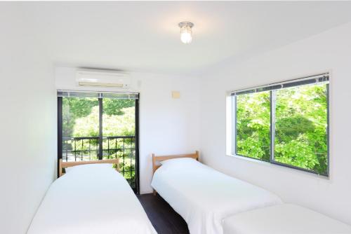 two beds in a room with two windows at Blanc - Vacation STAY 11098v in Atami