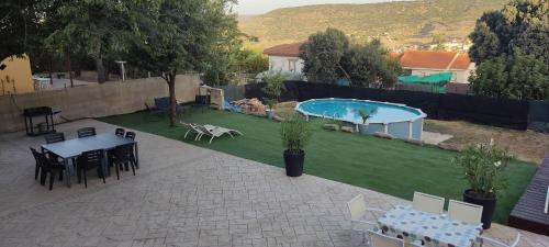 un patio con mesa y sillas y una piscina en Casa Ambite, en Ambite